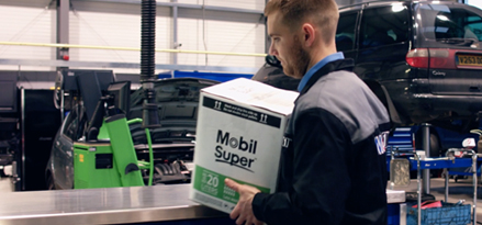 Man lifting a Mobil Super box