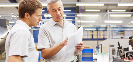 Someone pointing at a paper and discussing with the person next to them