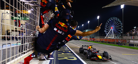 Red bull team celebrating as the car crosses the finish line 