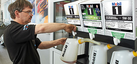 Mechanic pouring engine oil image